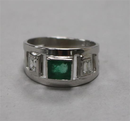 A modern 9ct white gold and emerald ring with diamond set shoulders, size K.